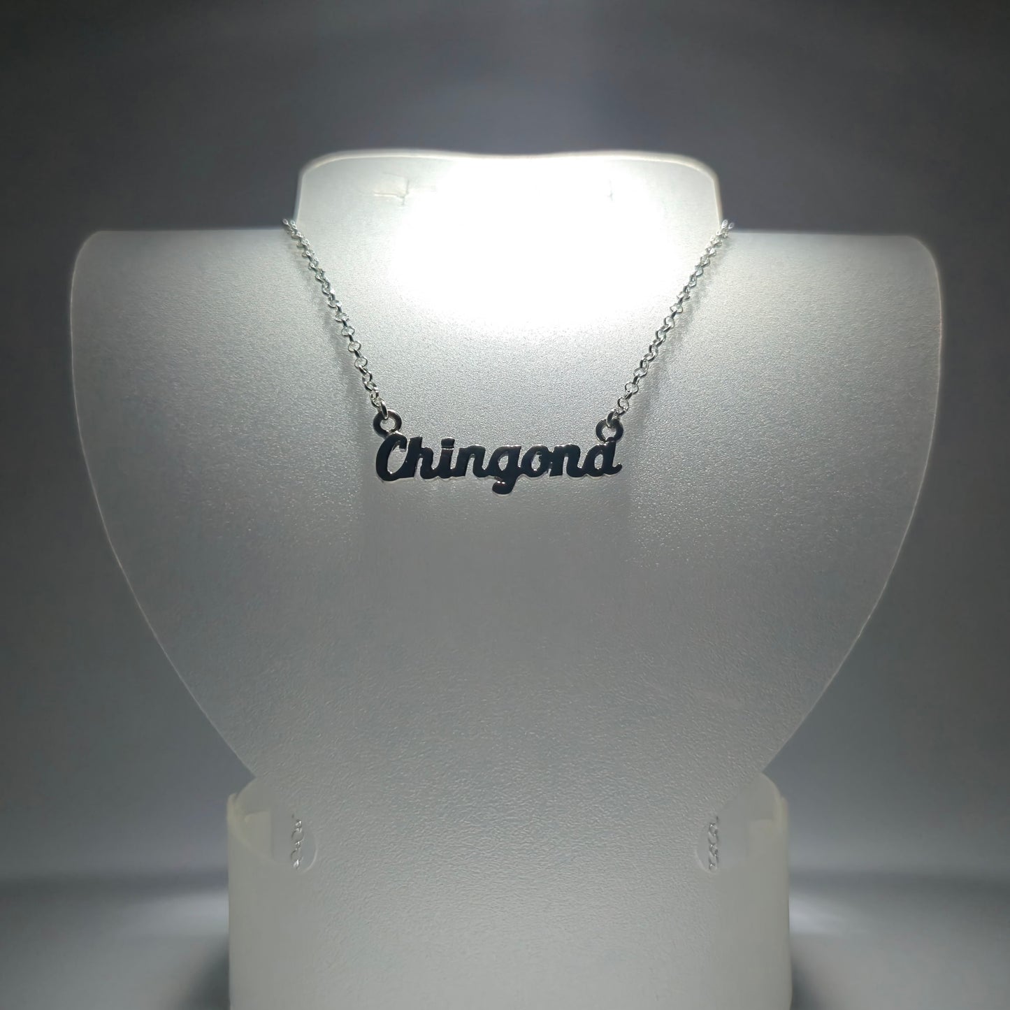 Silver chain necklace with the phrase "chingona" in silver